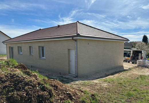 Maison en construction, avec des échafaudages et des murs extérieurs blancs
