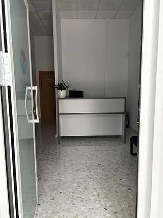 Hay un escritorio en el medio de la habitación.