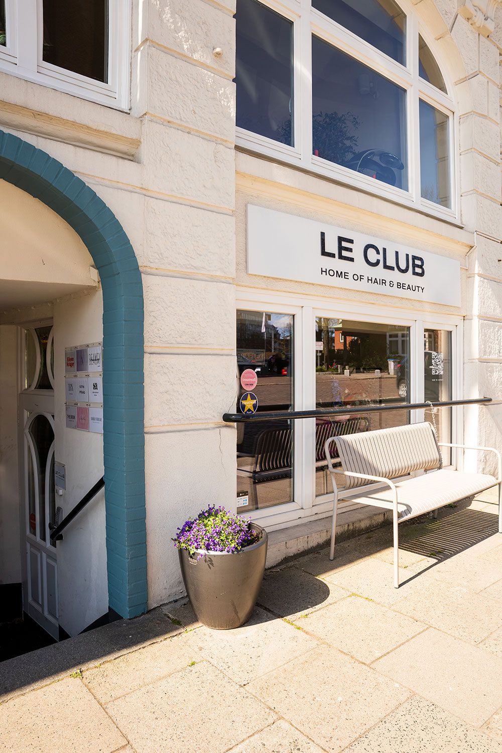 Ein weißes Gebäude mit einer Bank davor.