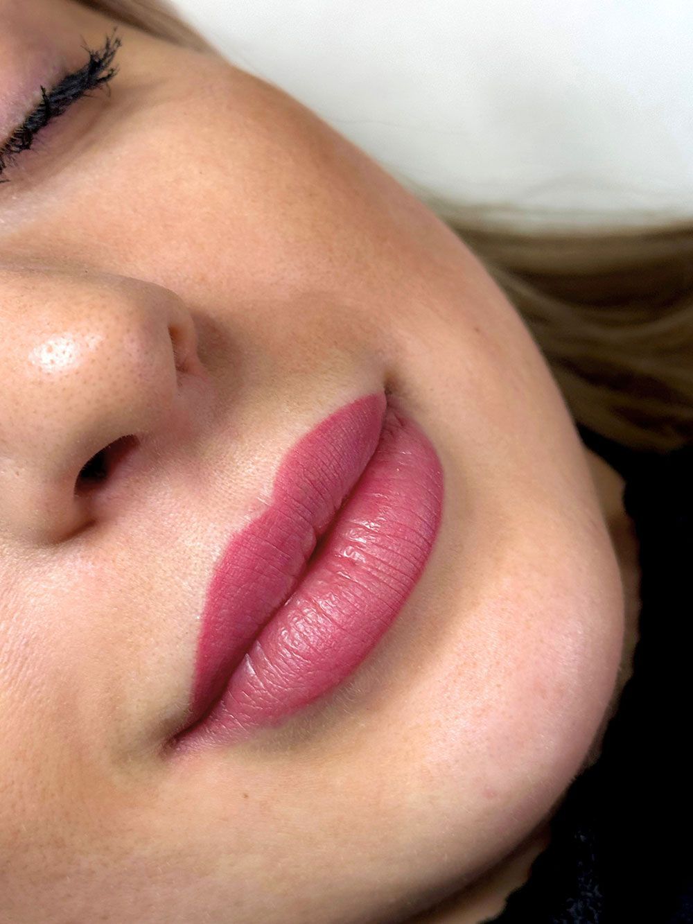 Eine Nahaufnahme des Gesichts einer Frau mit rosa Lippen.