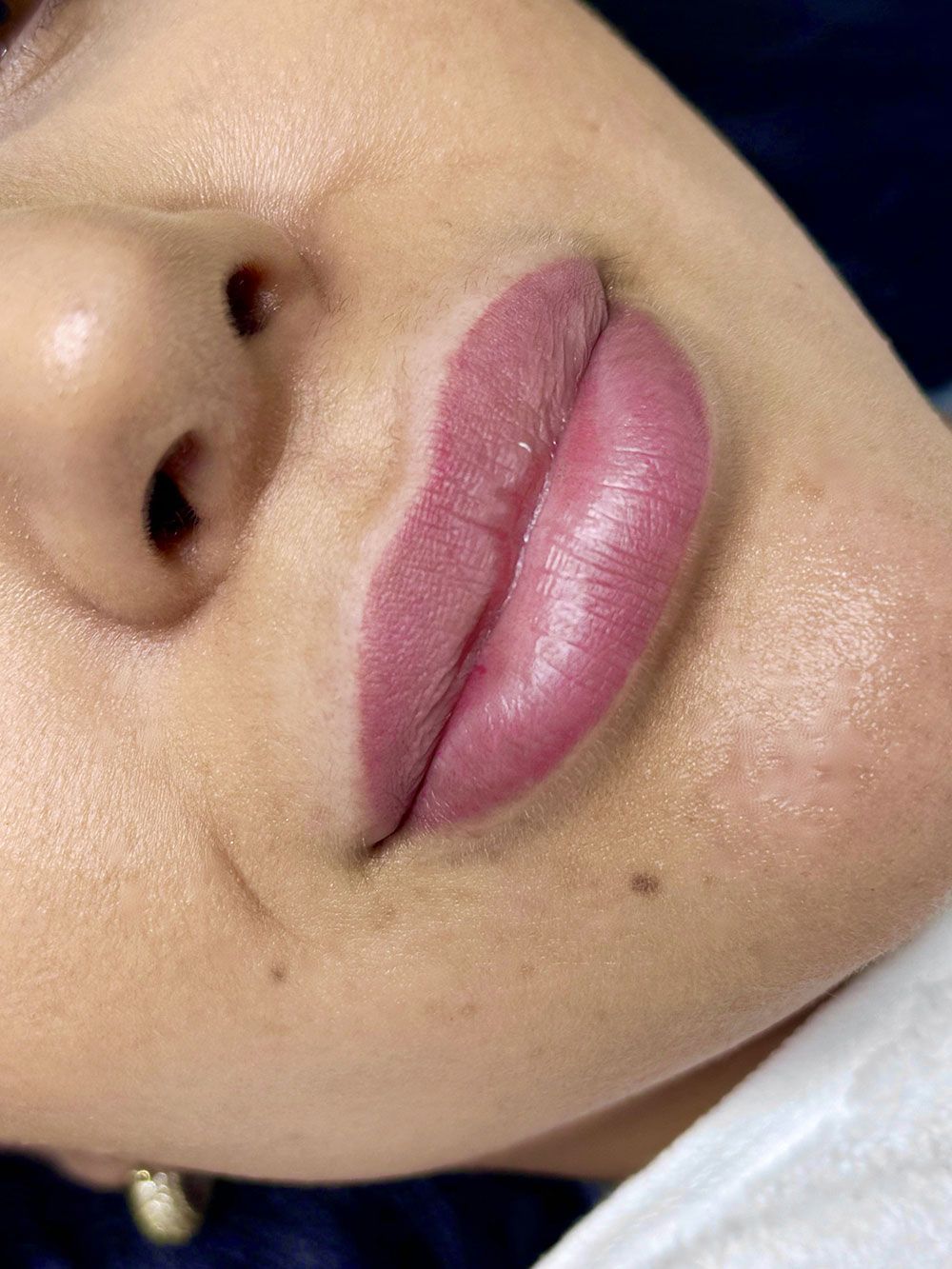 Eine Nahaufnahme der Lippen einer Frau mit rosa Lippenstift.