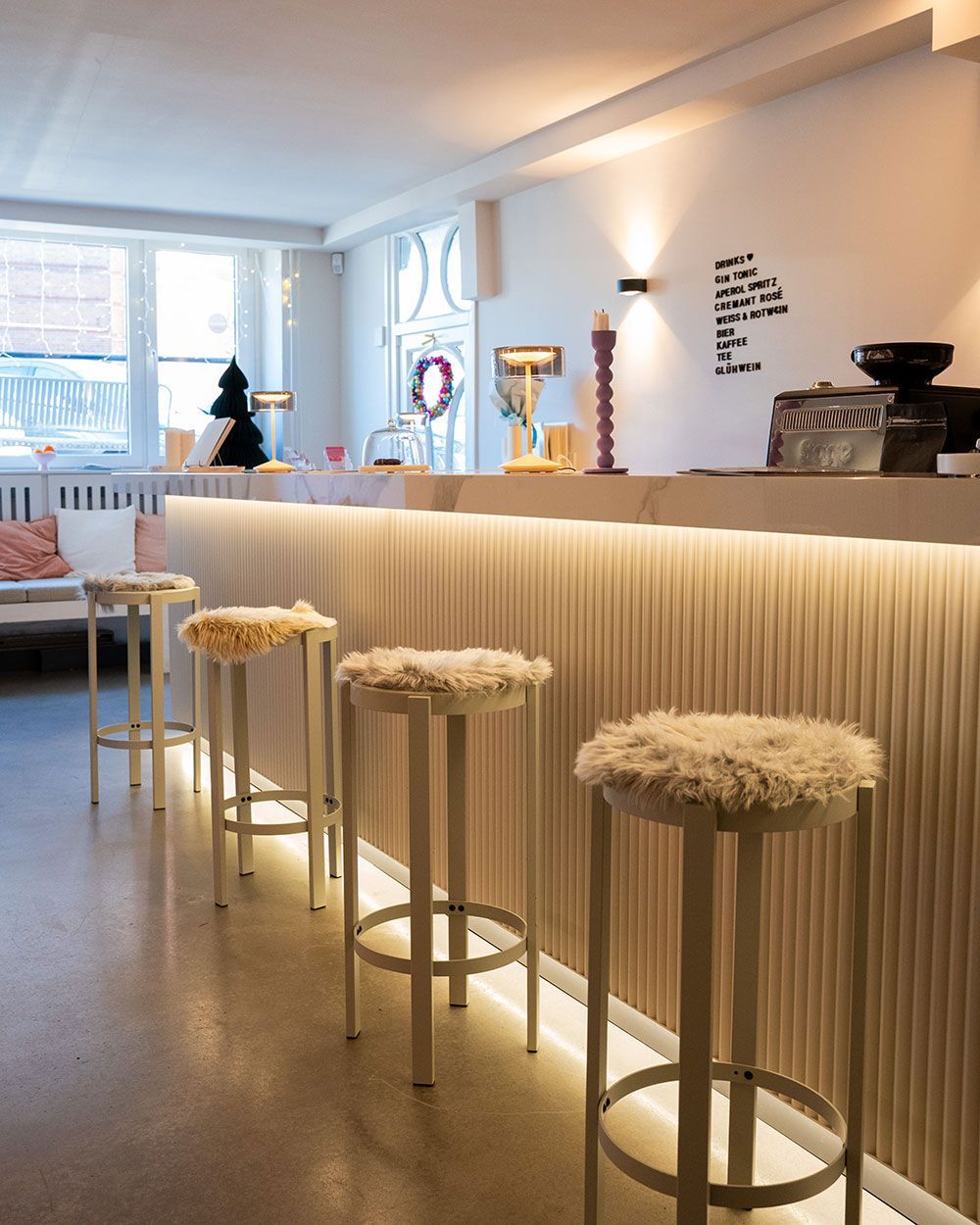 Eine Reihe von Barhockern sind vor einer Theke aufgereiht
