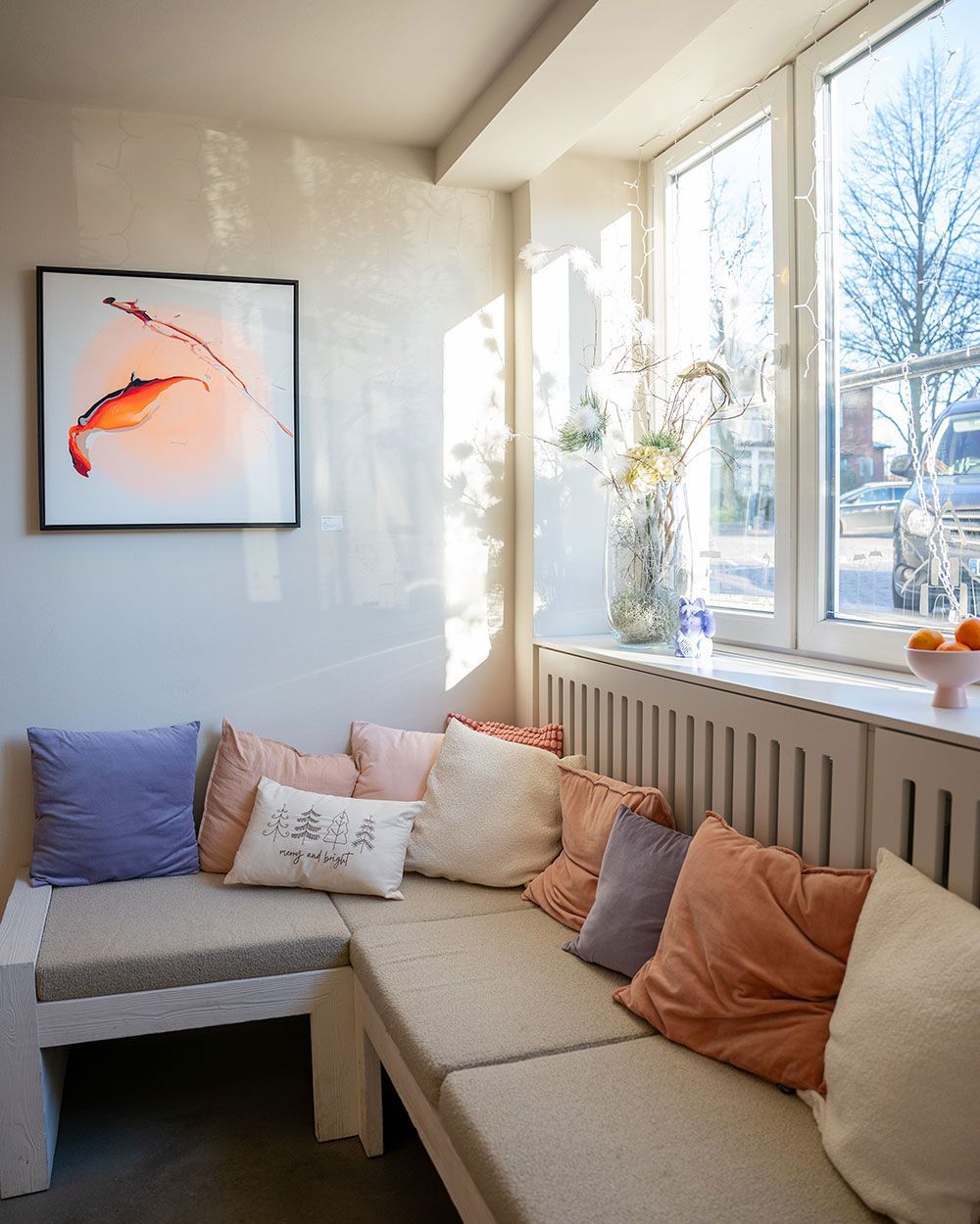 Ein Wohnzimmer mit einem Sofa und Kissen und einem Bild von einem Fisch an der Wand