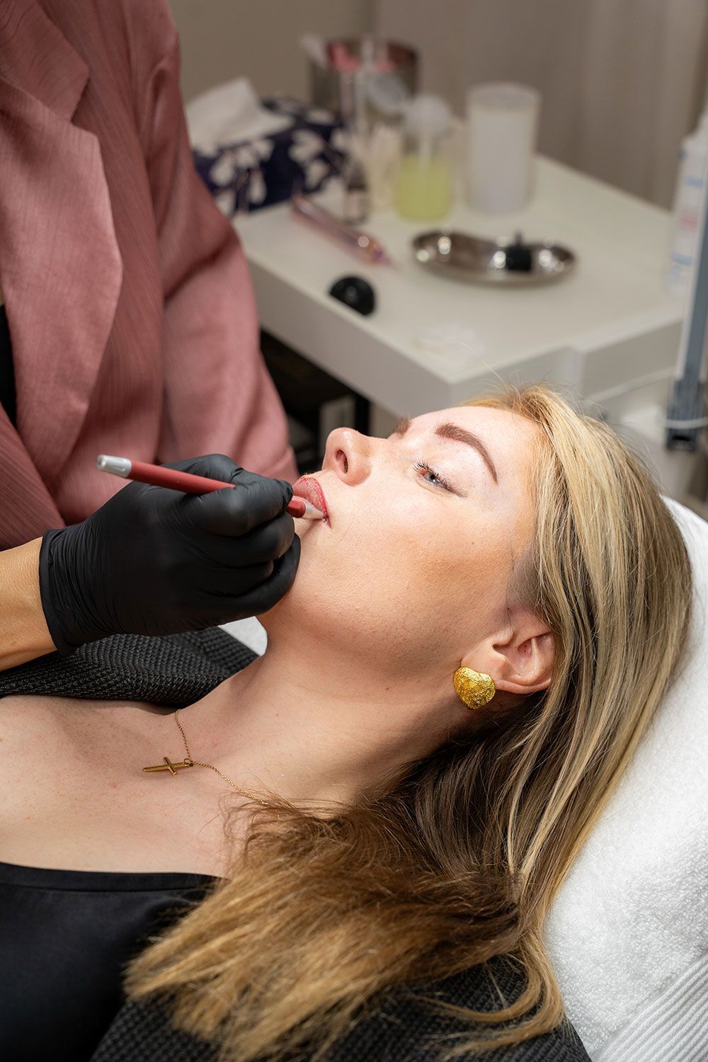 Eine Frau lässt sich in einem Schönheitssalon ein Lippentätowieren.