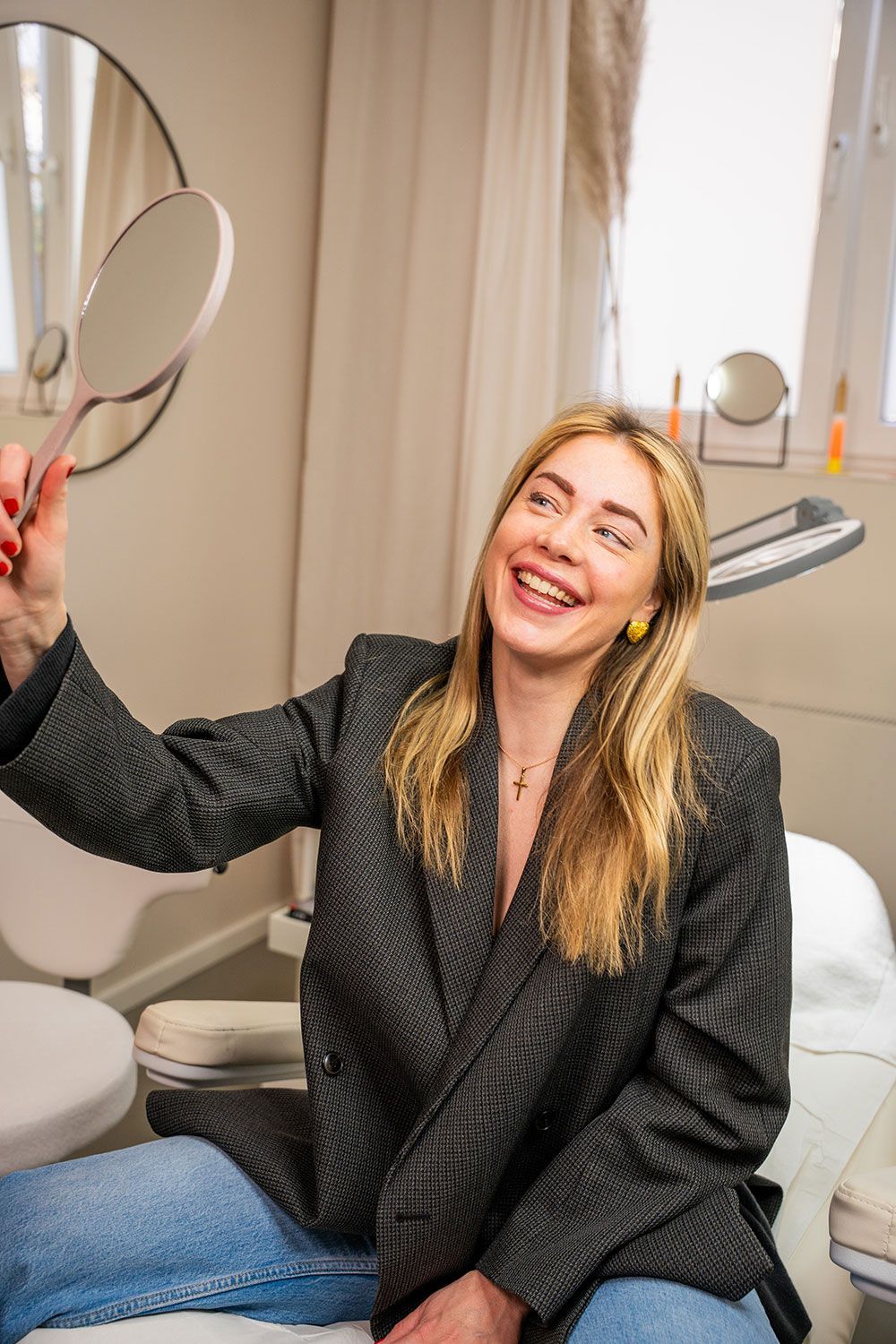 Eine Frau sitzt auf einem Stuhl und betrachtet sich im Spiegel.