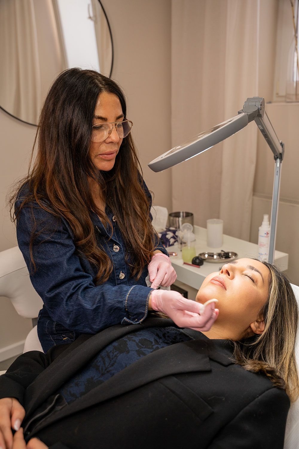 Eine Frau gibt einer anderen Frau in einem Schönheitssalon eine Gesichtsbehandlung.