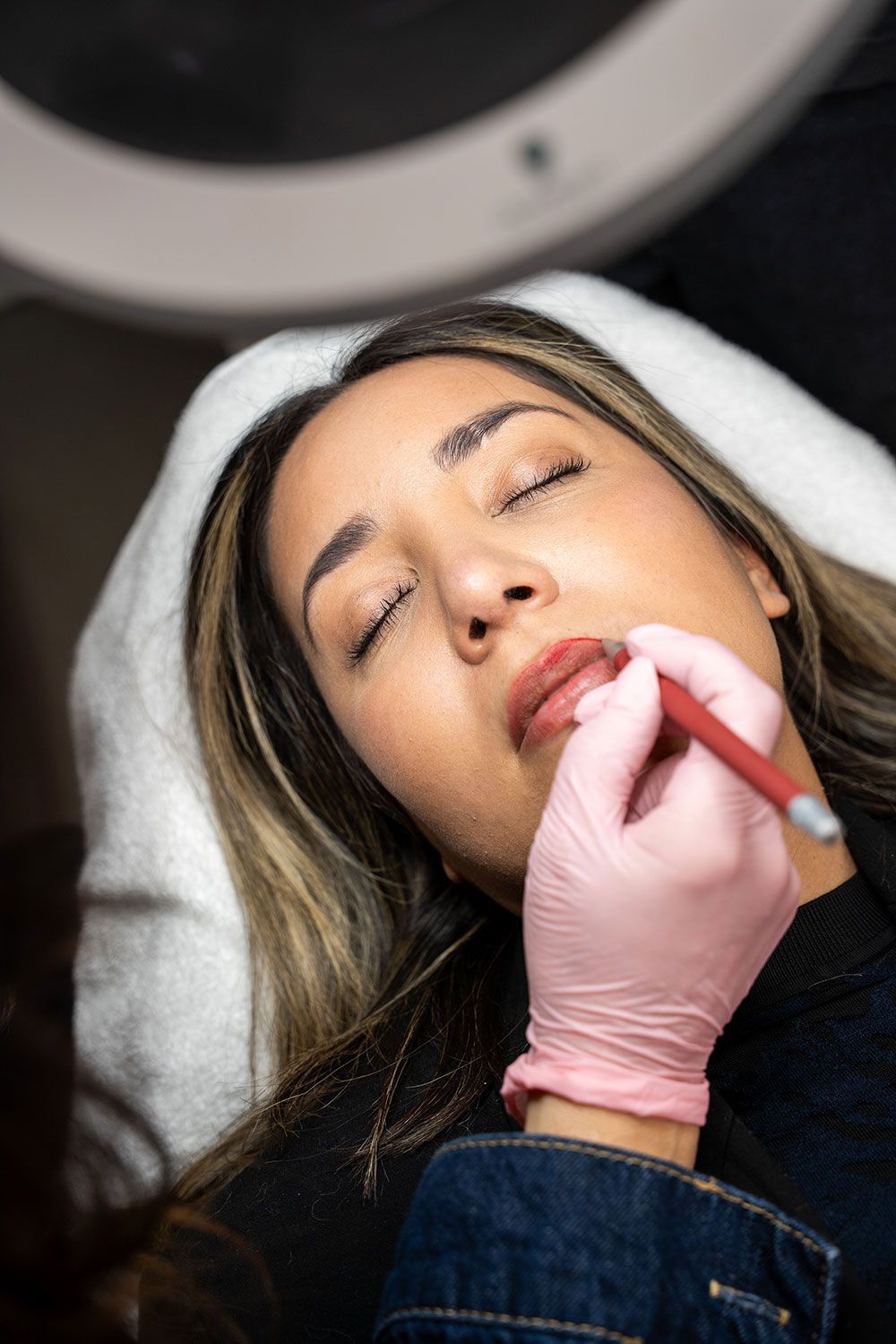 Eine Frau lässt sich in einem Schönheitssalon ein Lippentätowieren.