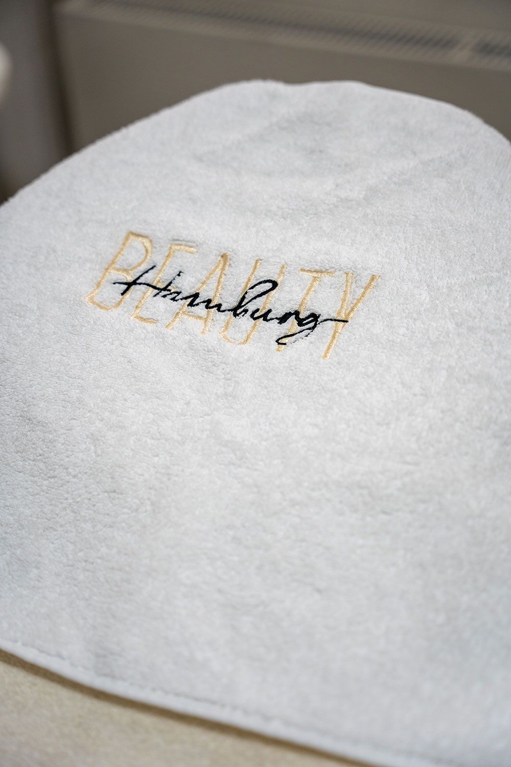 Ein weißes Handtuch mit dem aufgestickten Wort „Schönheit“.