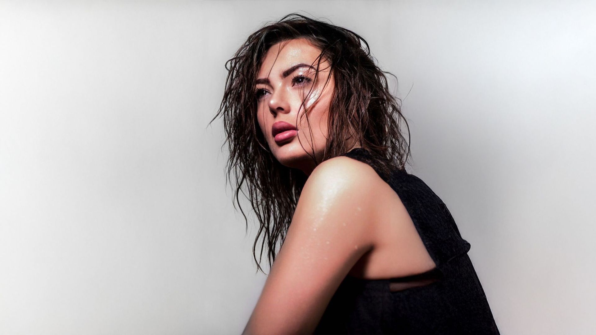 Eine Frau mit nassen Haaren trägt ein schwarzes Oberteil