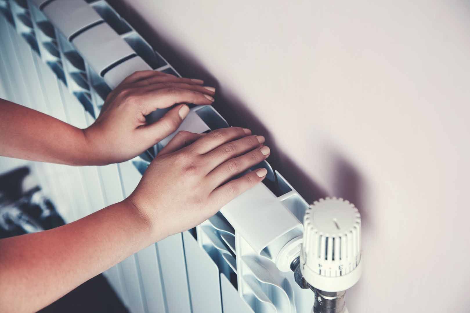 Des mains sur un radiateur