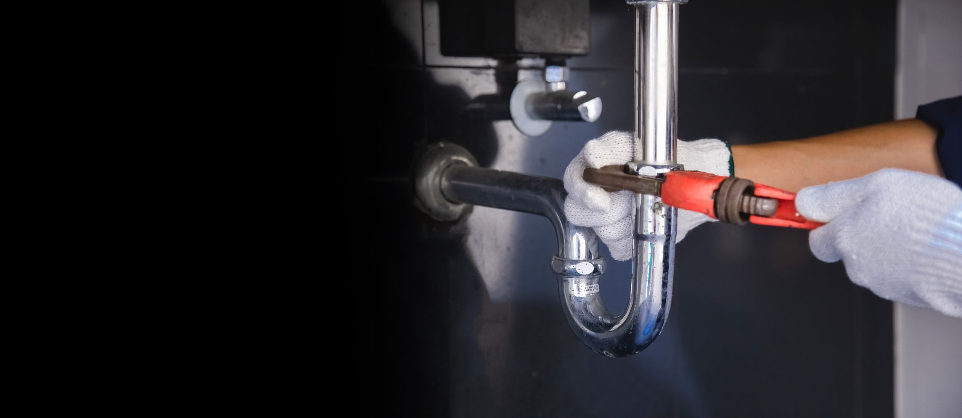 Plombier avec la main sur un siphon d'évier