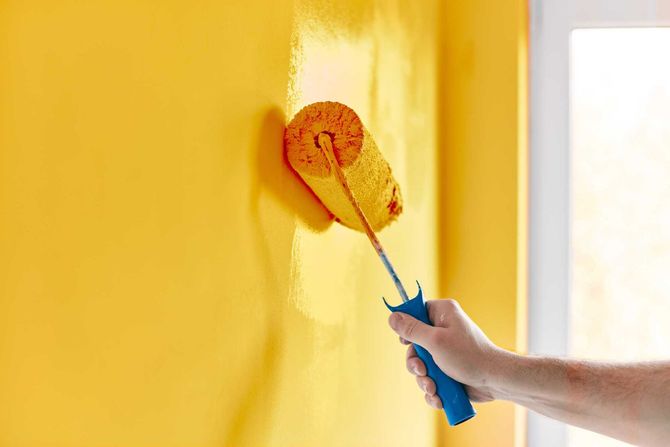 Wand wird mit gelber Farbe gestrichen