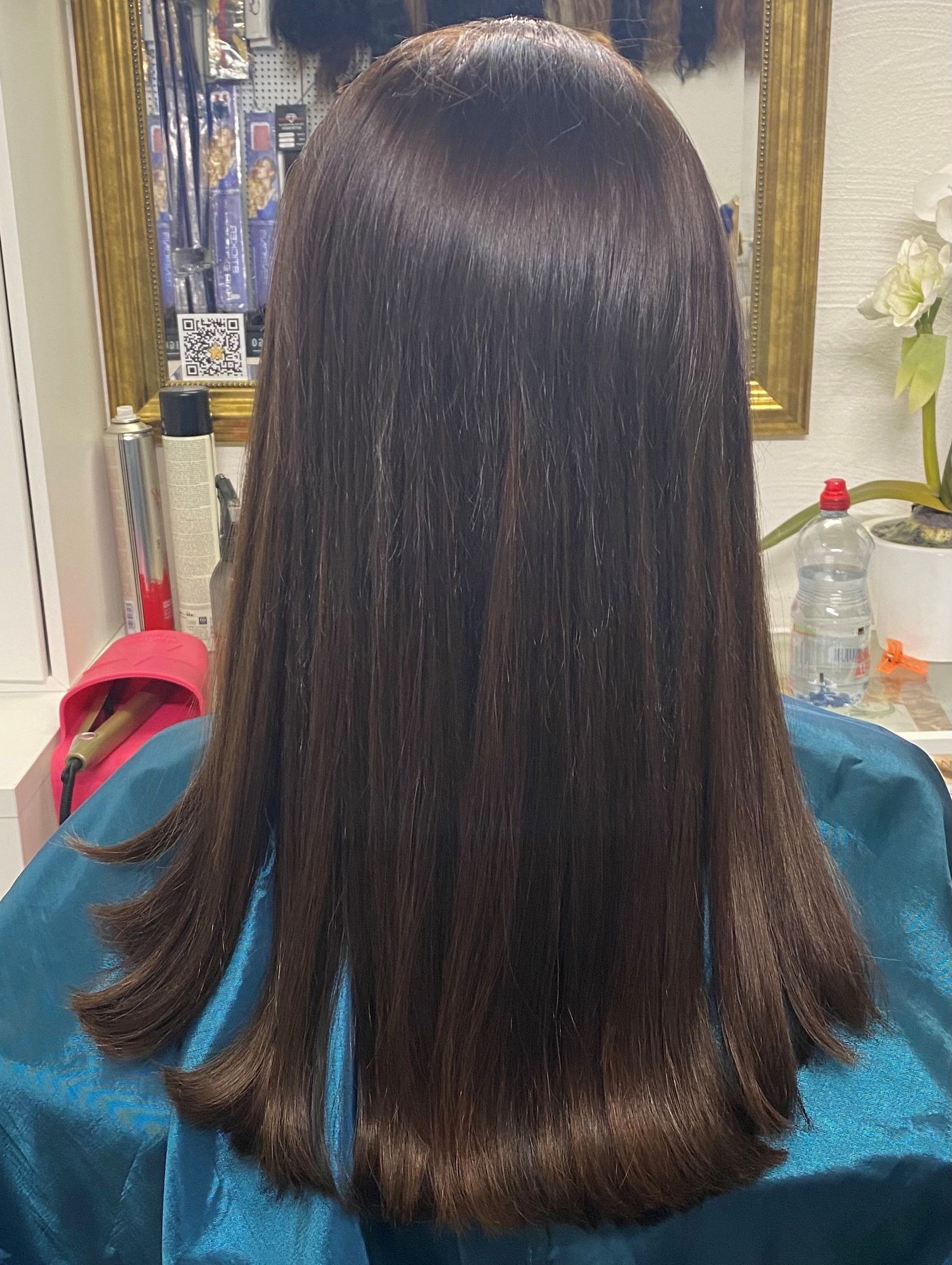 Dunkelbraunes, glattes Haar; Salon-Setting; das Haar ist nass und gestylt.