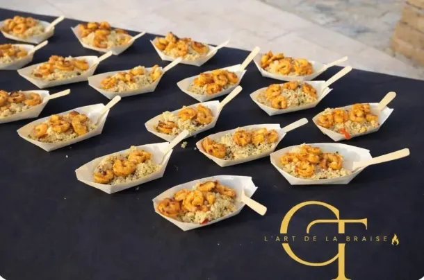 Amuse-bouches présentés dans des petits contenants blancs jetables, disposés sur une nappe noire.