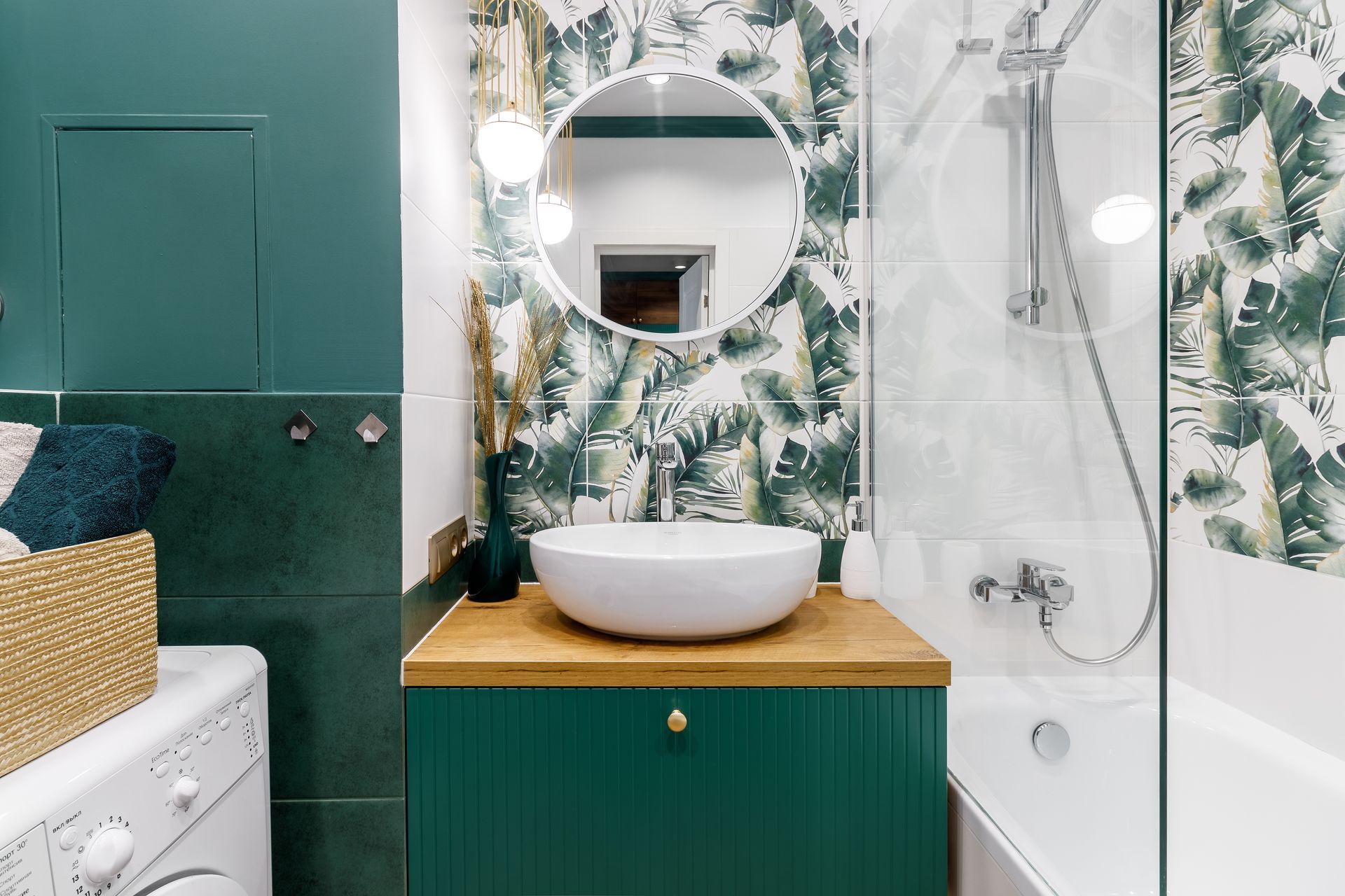 Une salle de bains moderne avec un meuble sous vasque avec un lavabo blanc, un miroir rond et un carrelage tropical.