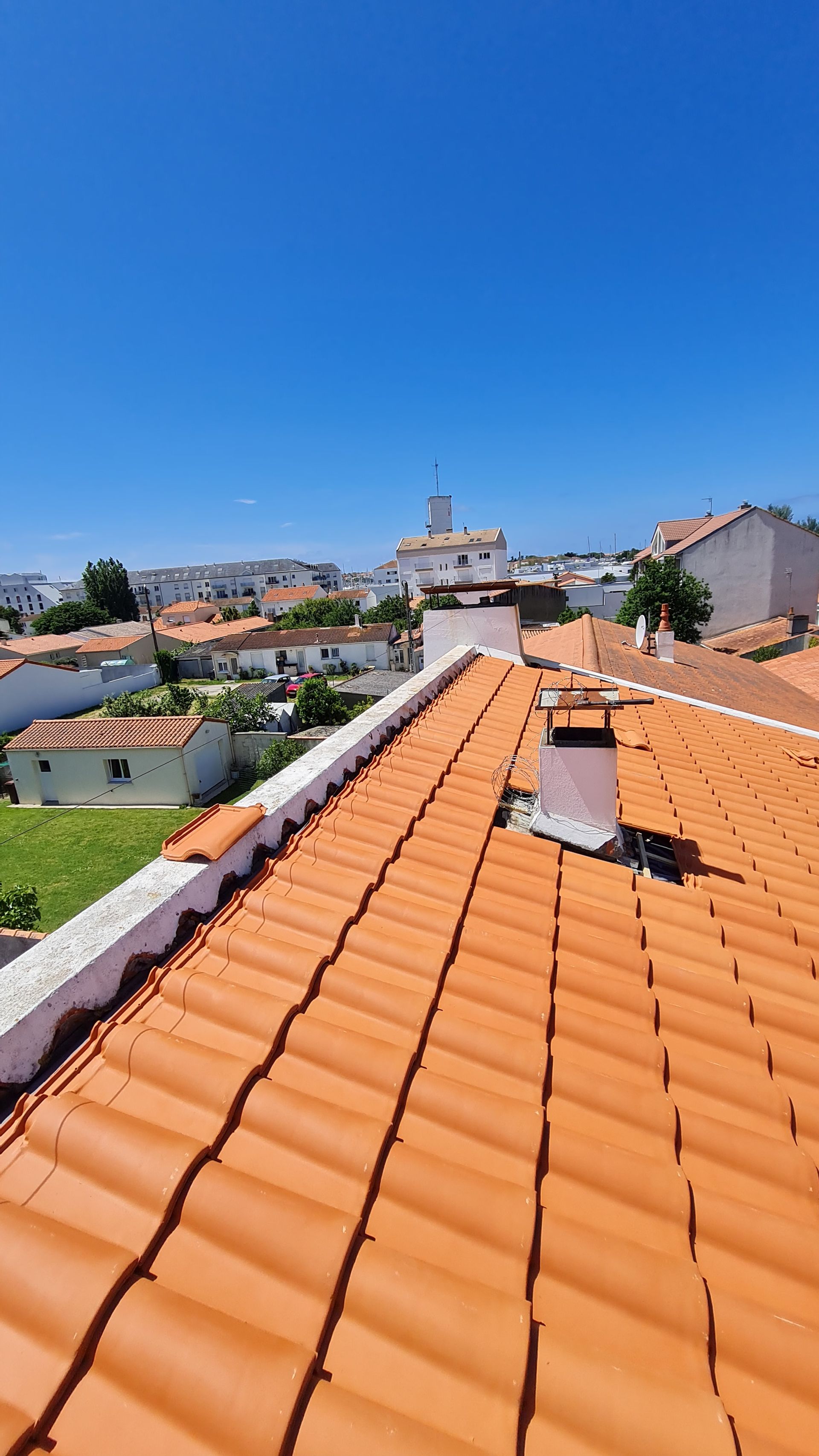 Photo de tuiles avec un conduit de cheminée sur un toit