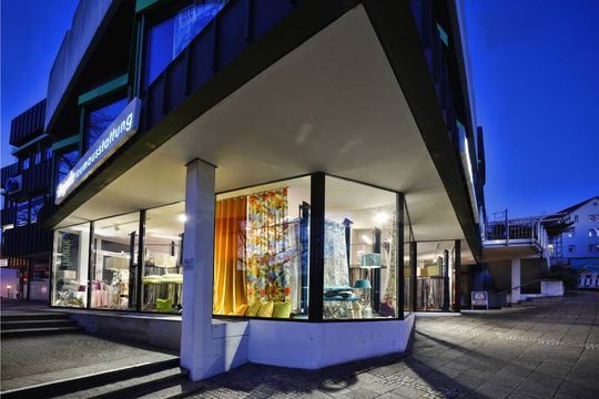 Bunte Dekokissen auf grauem Sofa