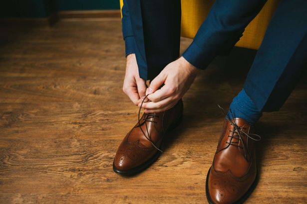 Ein Mann bindet sich die Schuhe zu