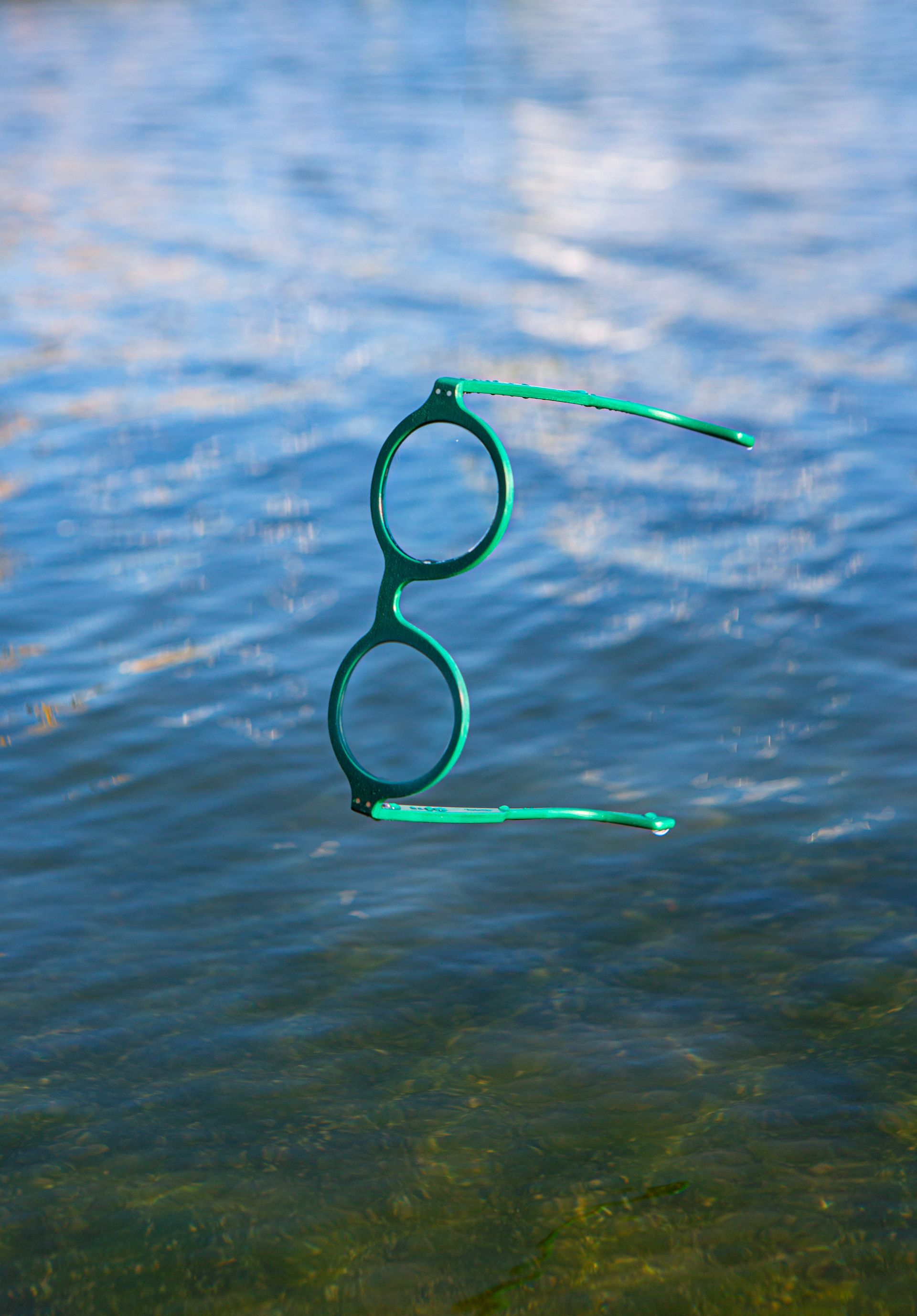 Eine grüne Brille schwimmt im Wasser.