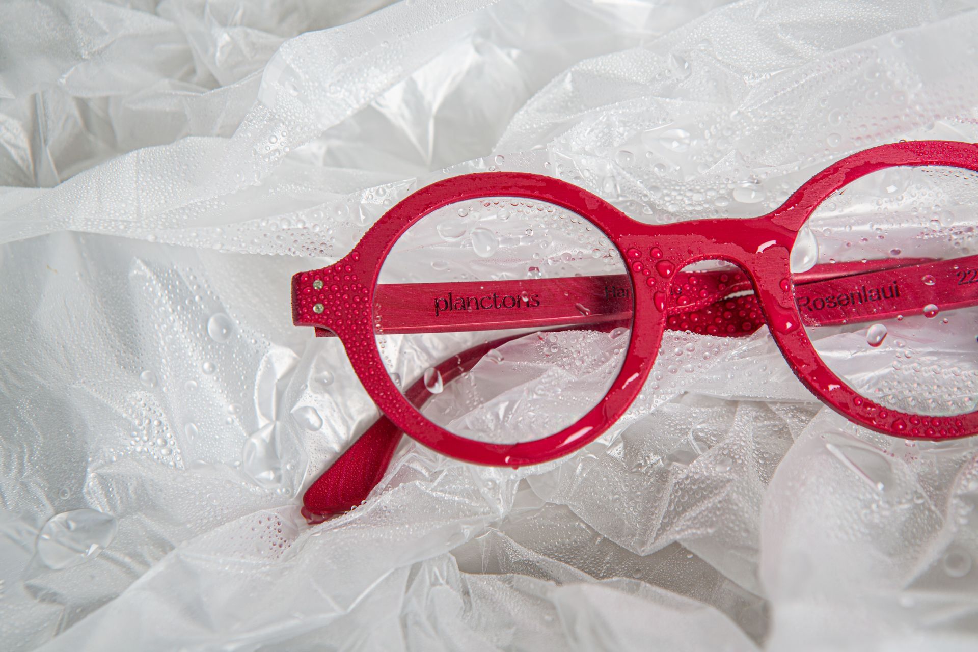 Eine rote Brille liegt auf einer weißen Plastiktüte.