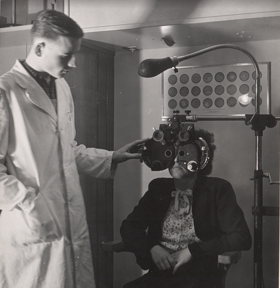 Ein Schwarzweißfoto eines Arztes, der die Augen einer Frau untersucht