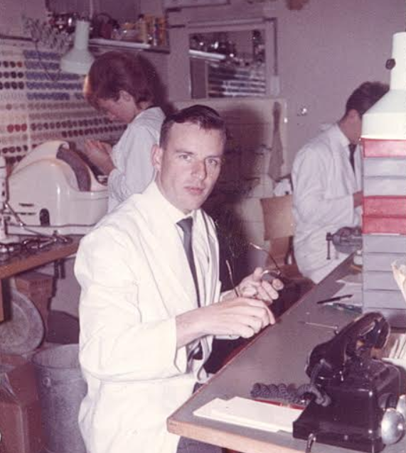 Ein Mann im Laborkittel sitzt an einem Schreibtisch