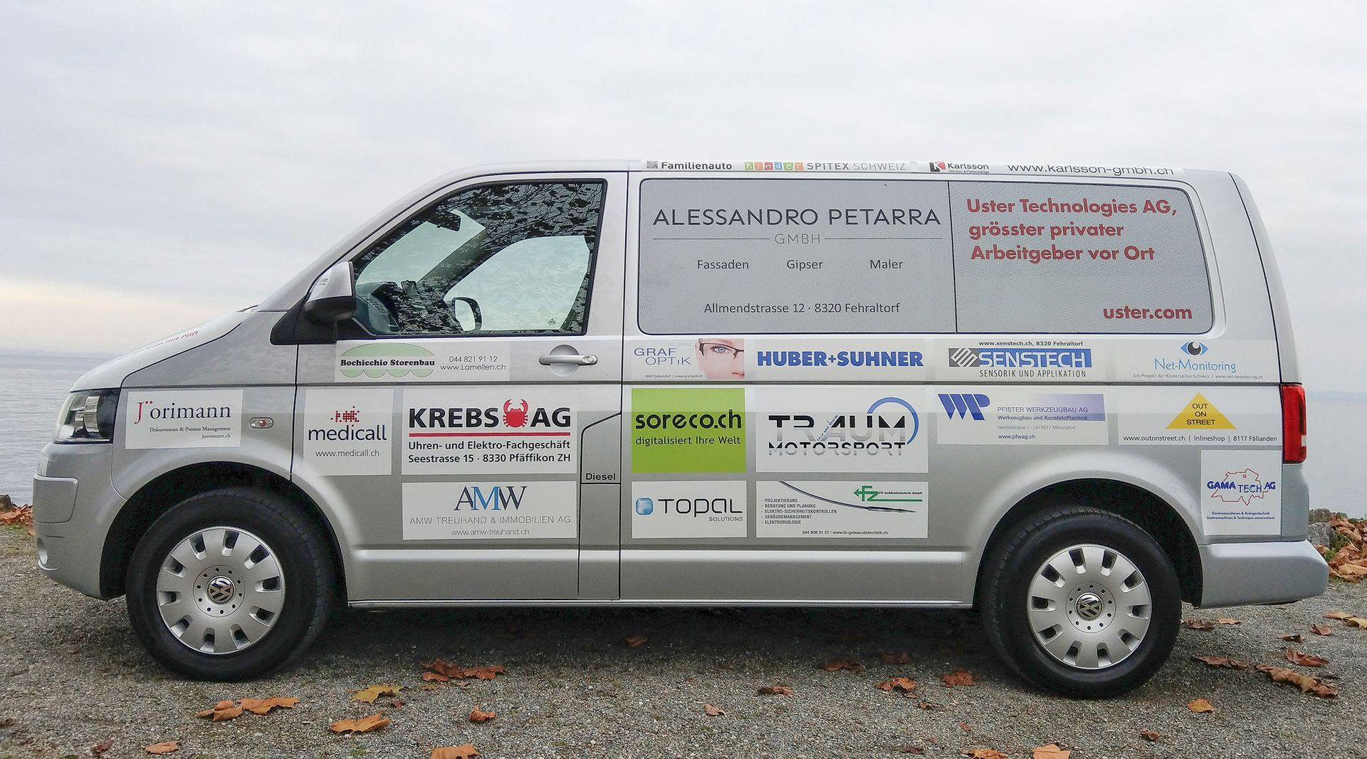 Ein silberner Van mit vielen Logos darauf