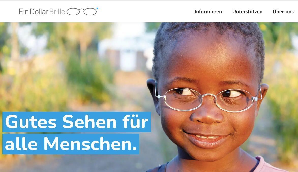 Ein kleines Mädchen mit Brille lächelt in die Kamera.
