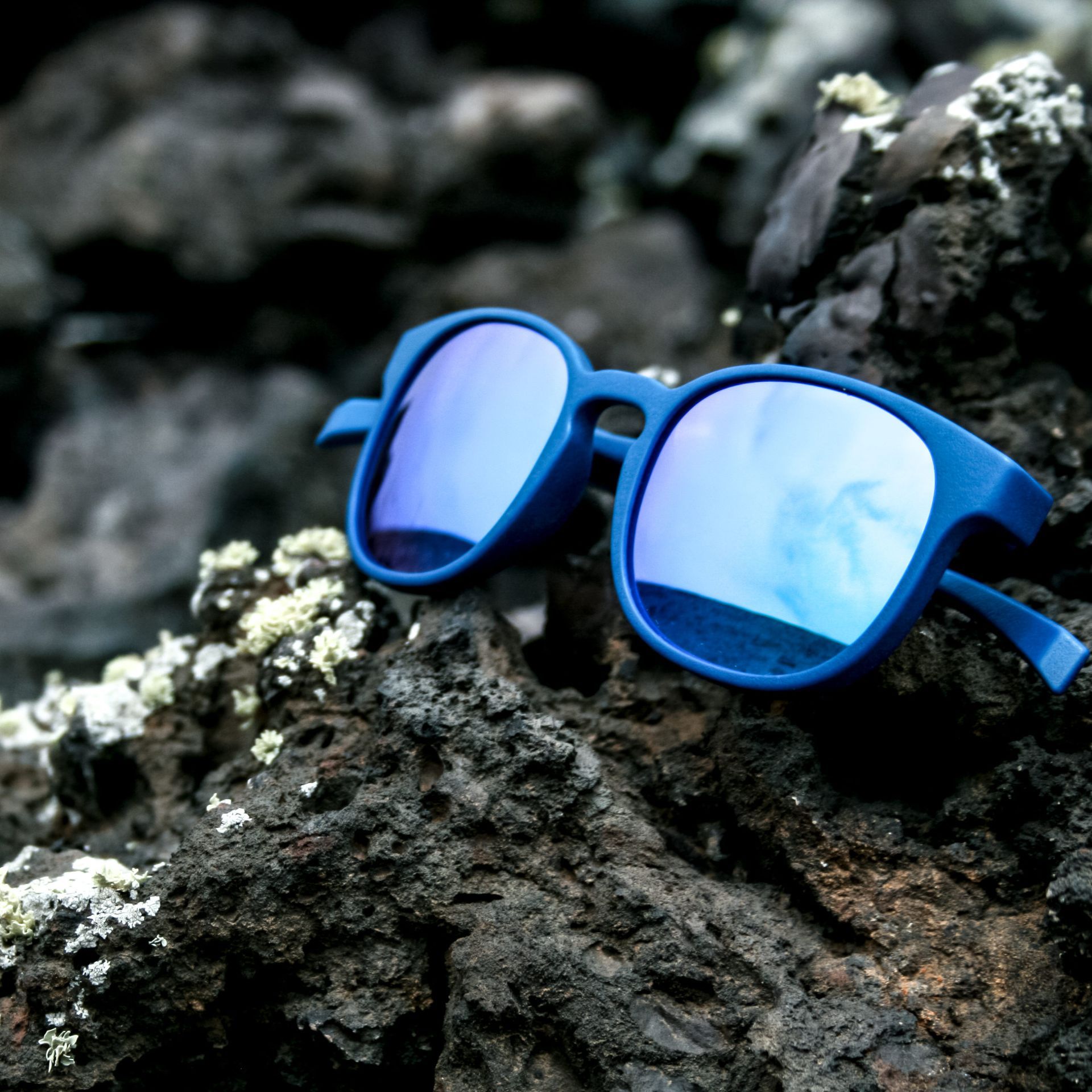 Eine blaue Sonnenbrille auf einem Felsen