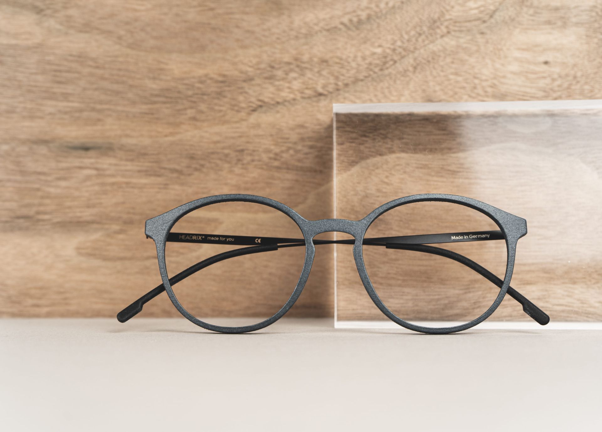 Eine Brille steht auf einem Holztisch.