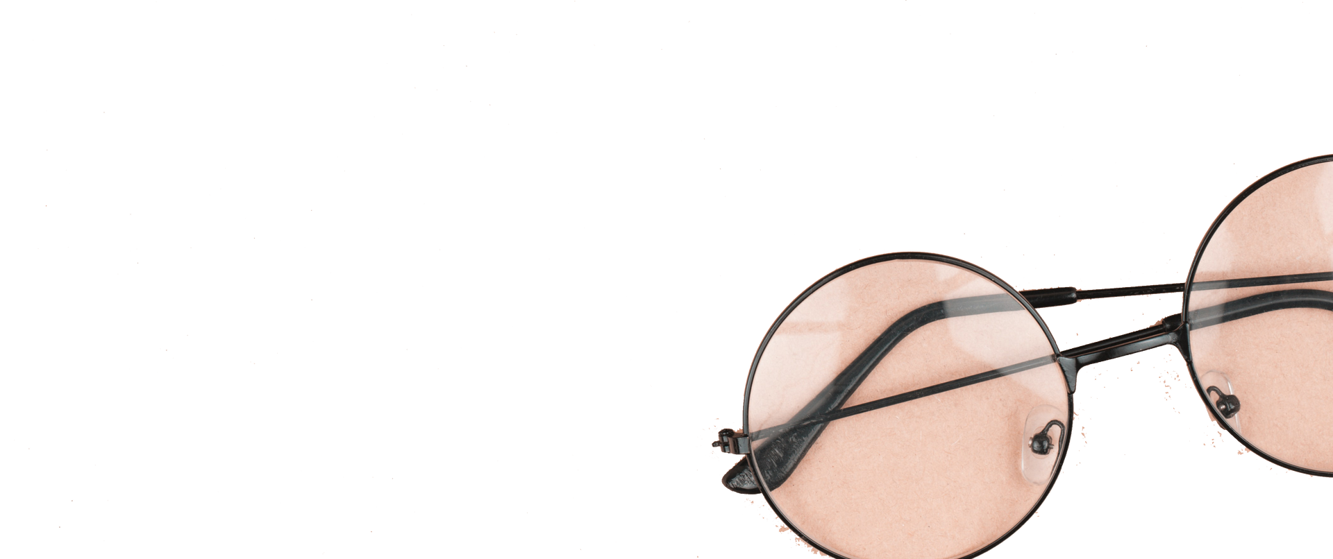 Eine runde Sonnenbrille mit rosa Gläsern auf weißem Hintergrund.