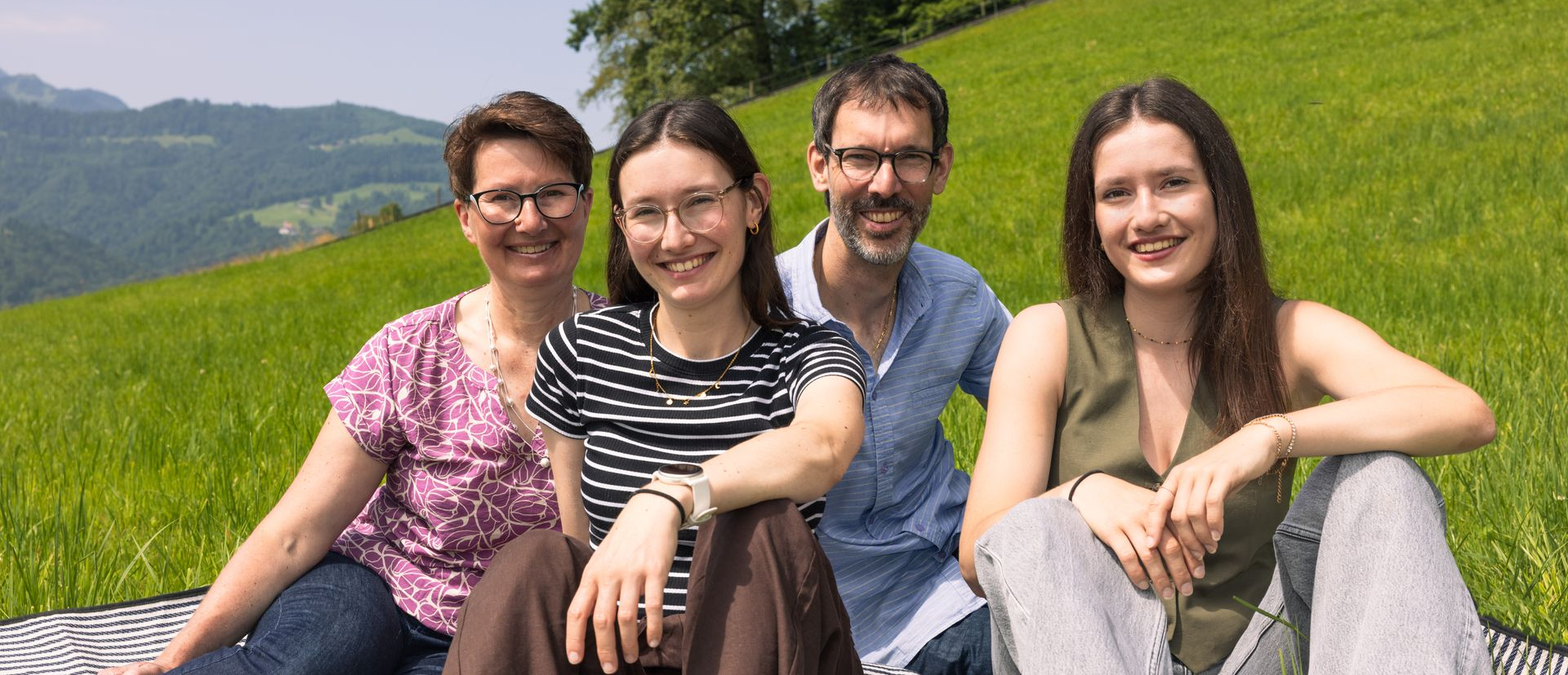 Vier Personen sitzend im Gras