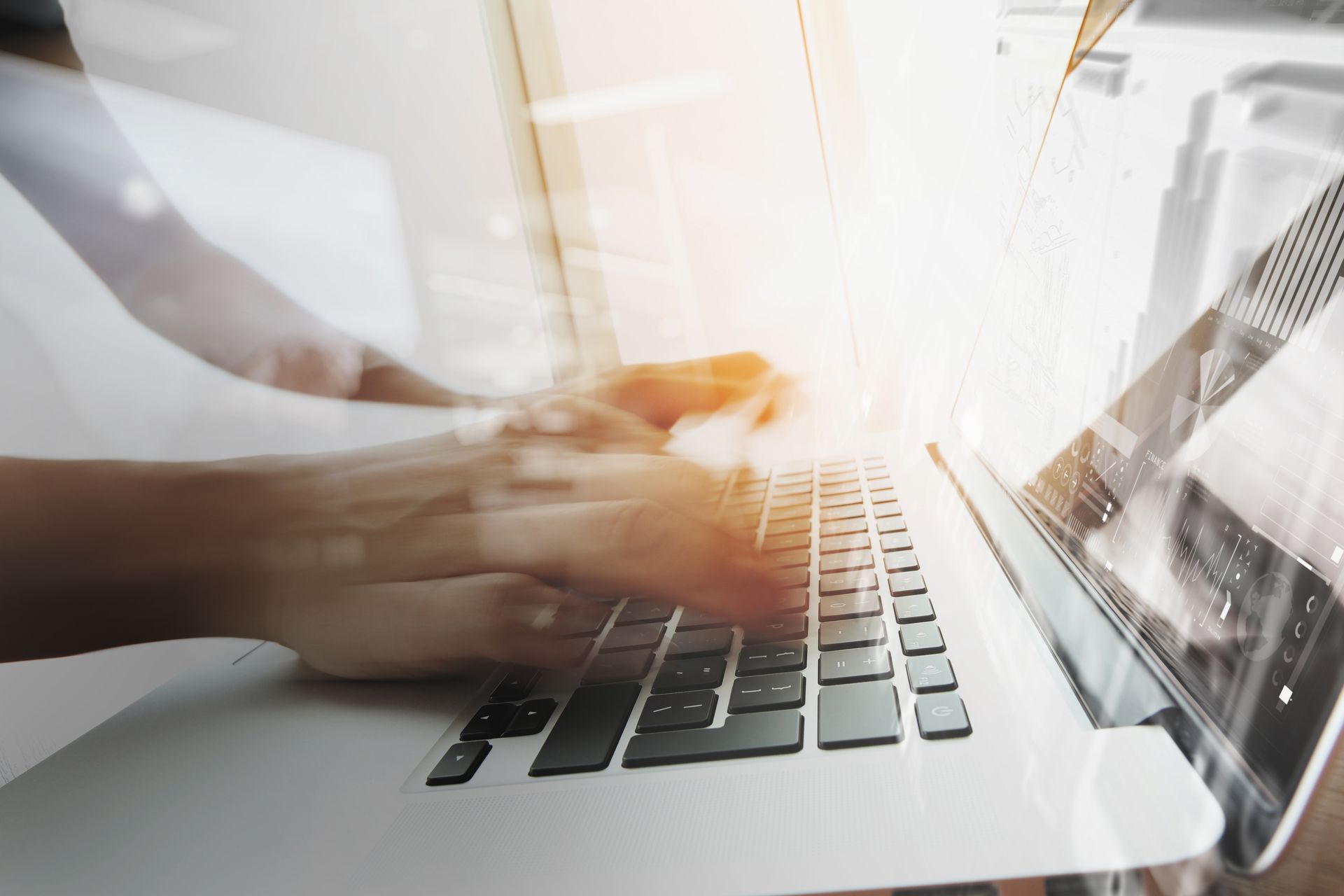 Des mains tapant sur le clavier d’un ordinateur portable, l’écran lumineux et le mouvement flou