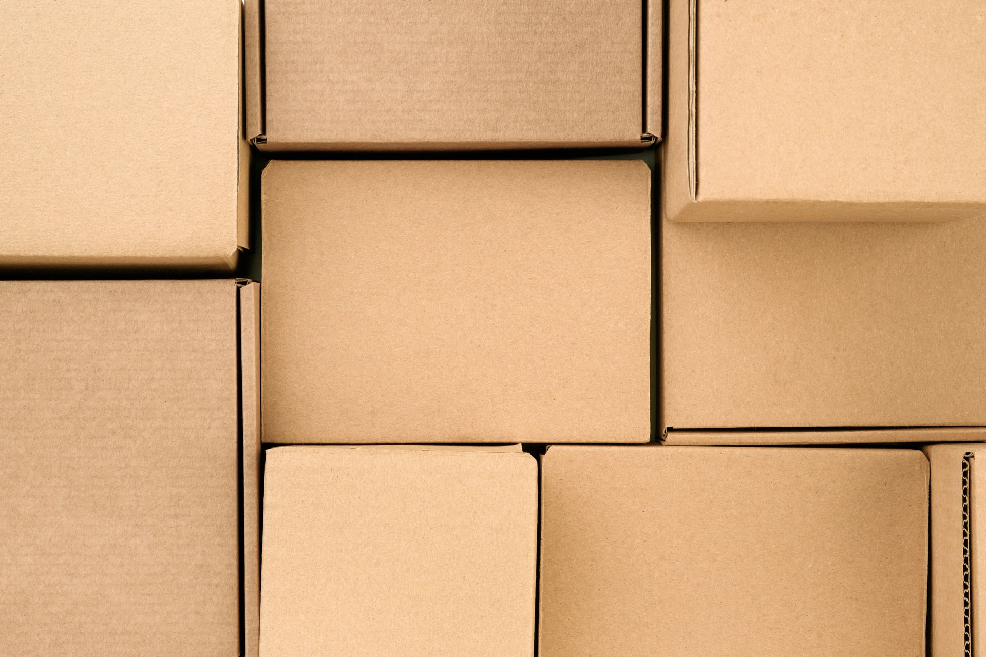 Des cartons empilés en gros plan, avec leur emballage brun clair occupant tout le cadre