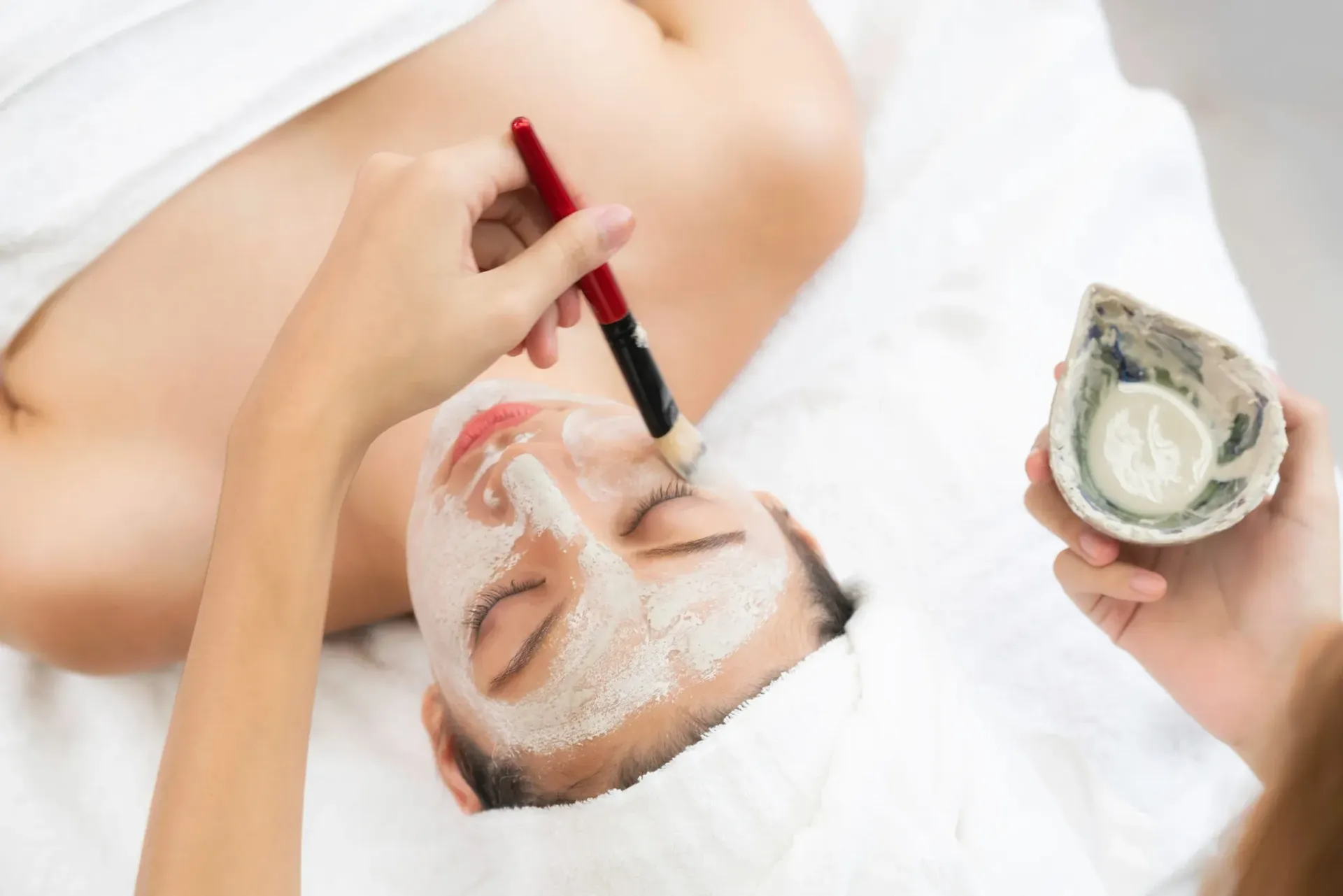 Persona acostada con mangas de terapia de compresión en las piernas; una mano ajusta la envoltura.