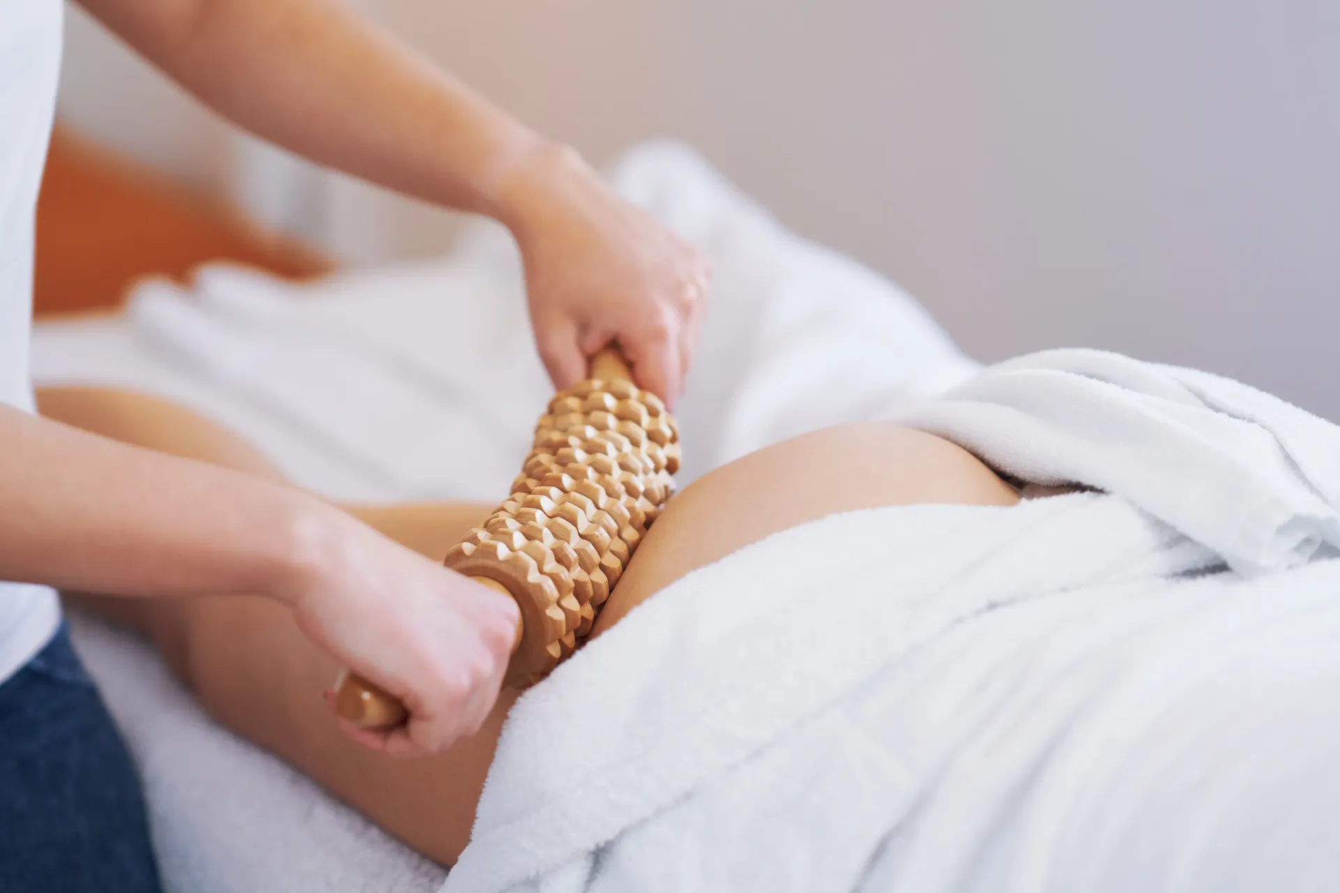 Persona acostada con mangas de terapia de compresión en las piernas; una mano ajusta la envoltura.