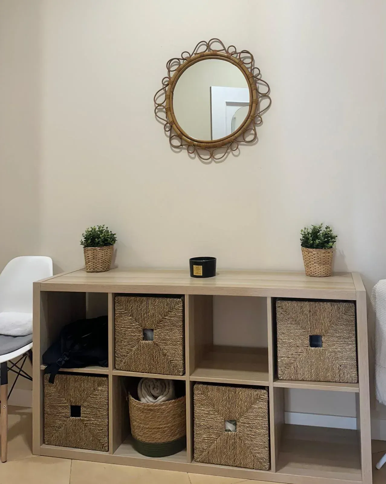 Manos con guantes azules sumergiendo un pie en un baño de cera tibia para un tratamiento de spa.