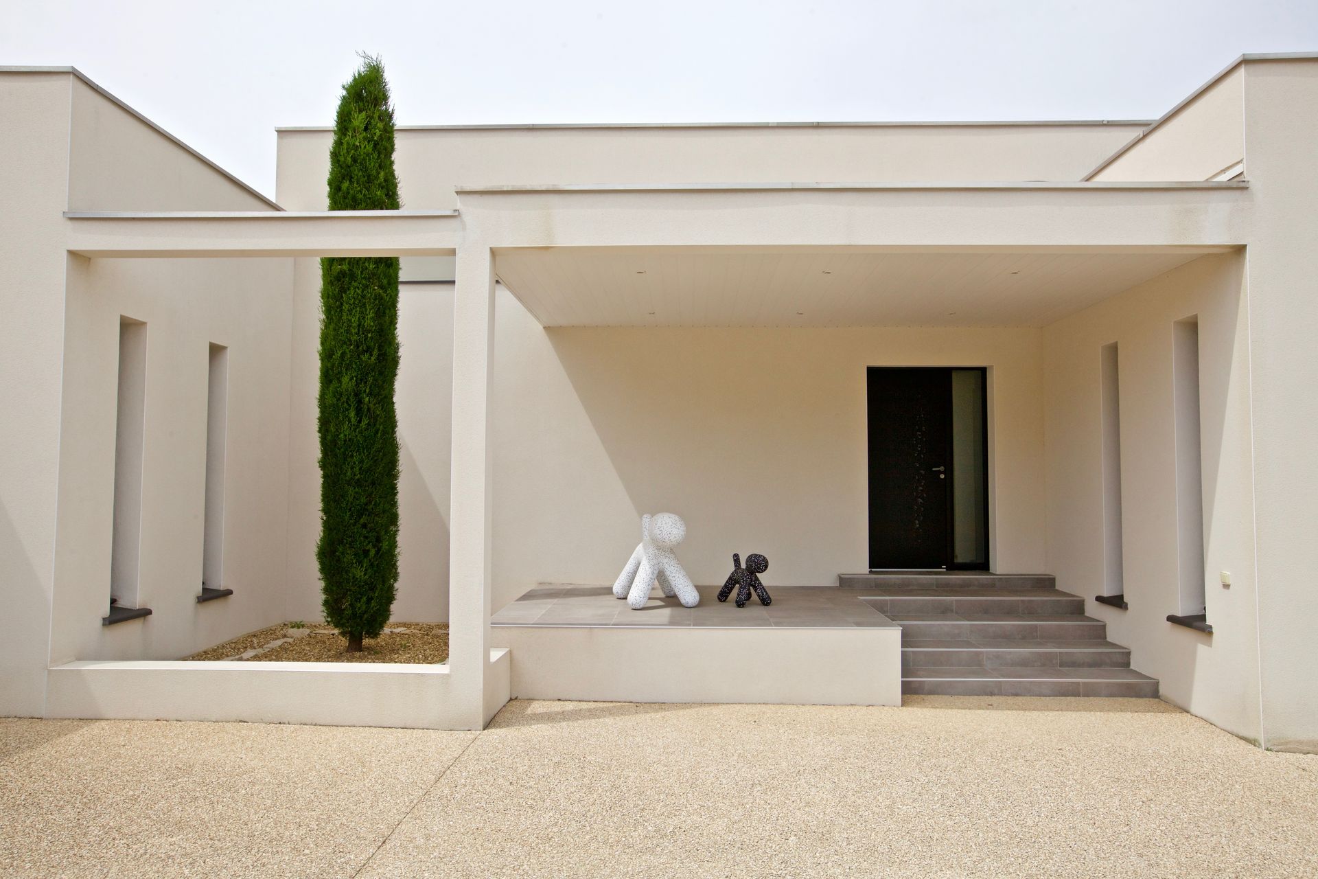 Entrée d'une maison moderne avec sculptures de chien