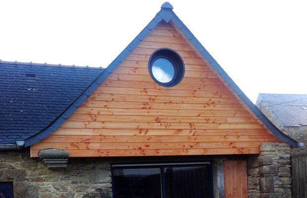 Bardage en bois sur toit d'une maison en pierre