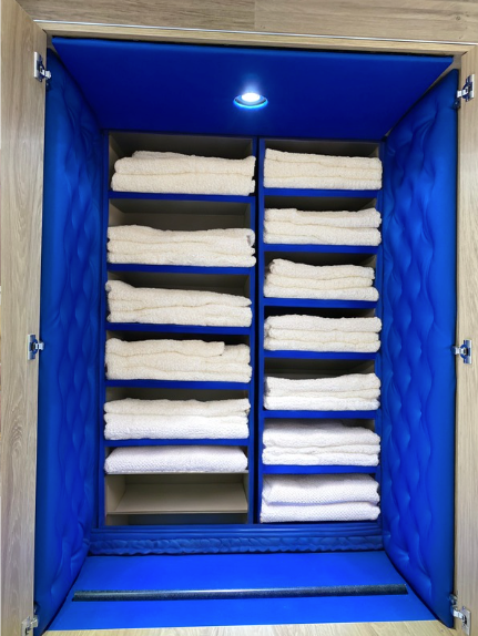 Intérieur d'une armoire avec des panneaux capitonnés bleus en skai avec linges blancs