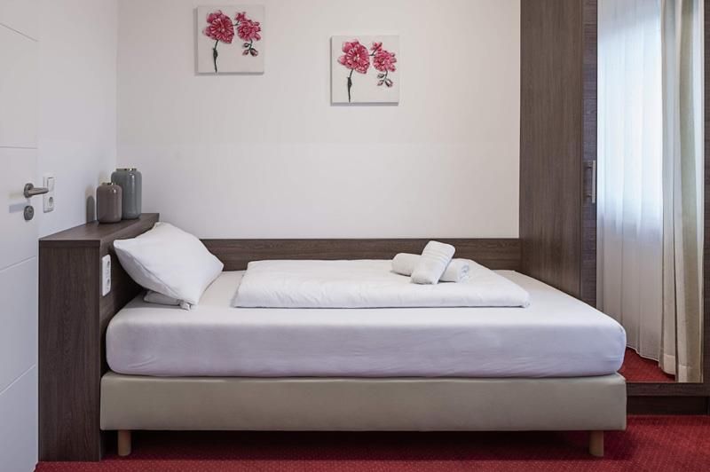 Ein Schlafzimmer mit einem Bett und zwei Gemälden an der Wand.