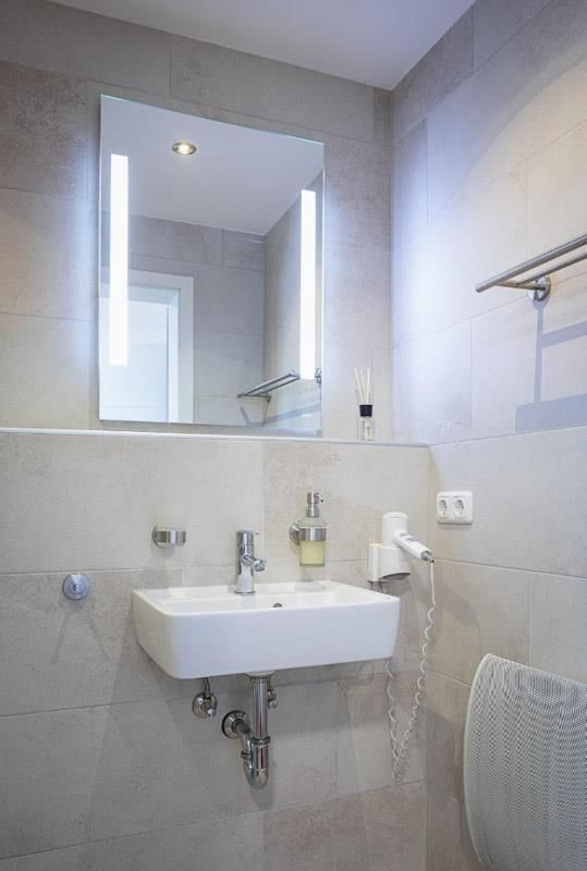 Ein Badezimmer mit Waschbecken, Spiegel und Haartrockner.