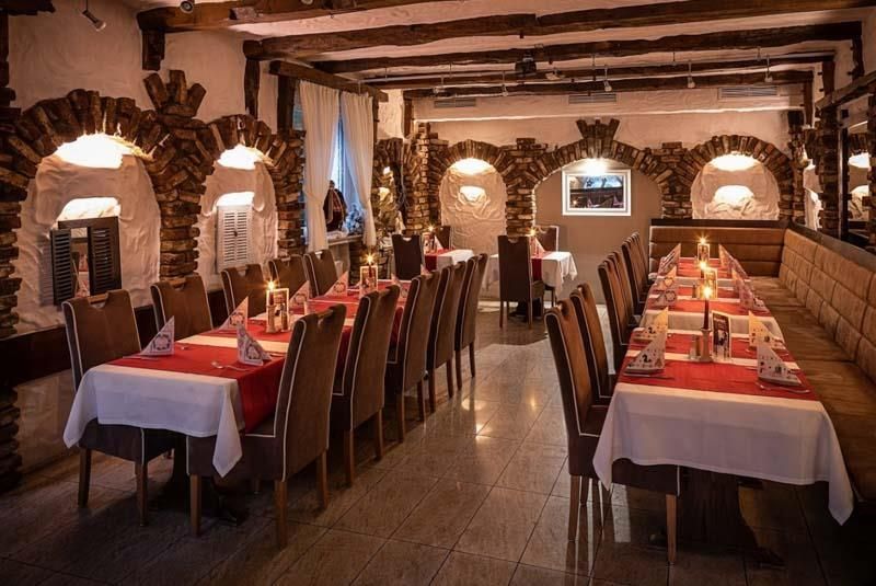 Ein Restaurant mit Tischen und Stühlen, die für eine Dinnerparty aufgestellt sind.