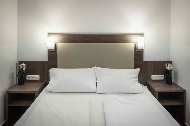 Ein Hotelzimmer mit einem Bett und zwei Nachttischen.