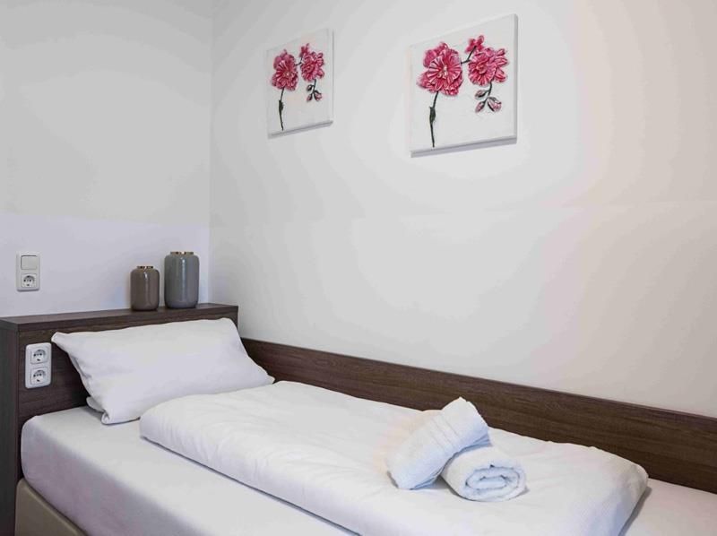 Ein Schlafzimmer mit einem Einzelbett und zwei Gemälden an der Wand.