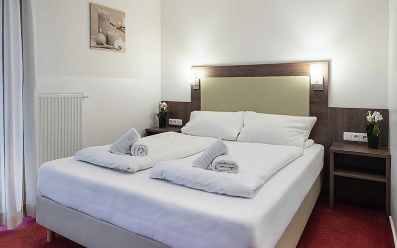 Ein Hotelzimmer mit einem Bett und zwei Nachttischen