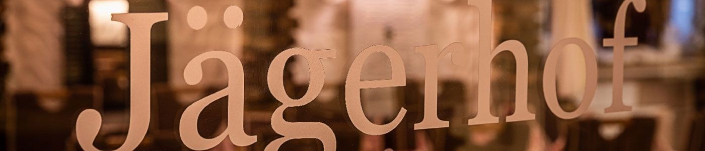 Das Wort „Jagen“ steht auf einem Fenster mit verschwommenem Hintergrund.