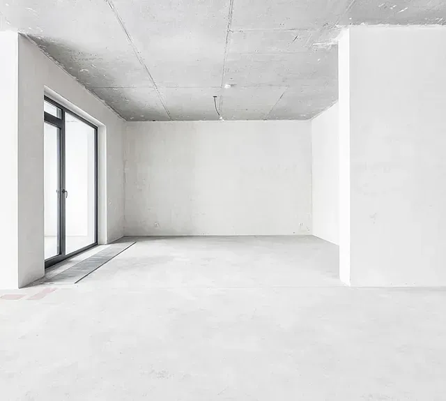 Una habitación vacía con paredes blancas y una ventana grande.