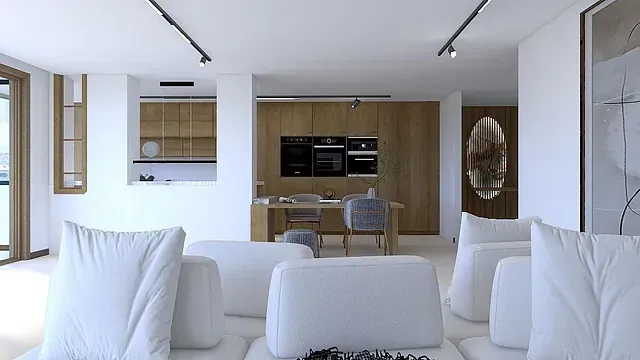 Una sala de estar con muebles blancos y una cocina al fondo.