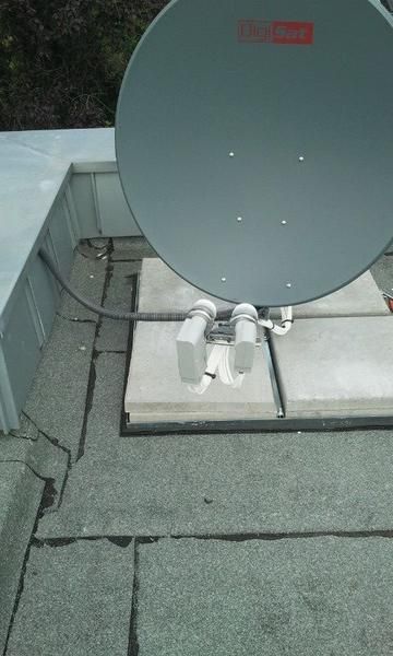 Auf einem Dach steht eine Satellitenschüssel.